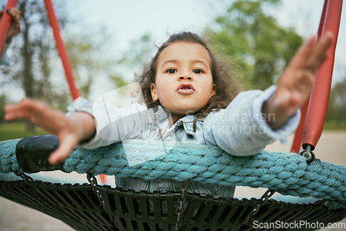 Image of Young girl play in playground, park and outdoor with portrait, fun and early childhood development with toddler. Kid, freedom and swing, playful and playing during holiday and growth in nature