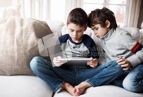 Image of Sibling boys, tablet and couch for games, relax and digital app for learning, web streaming or movie. Kids, sofa and mobile tech on social media, education or video for development, reading or gaming