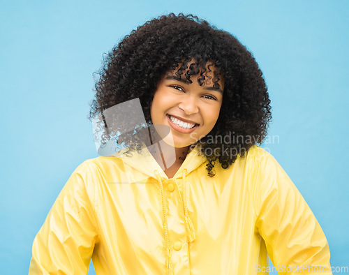 Image of Woman, smile and happy in portrait with fashion for winter, rain coat and beauty isolated on blue background. .African person, happiness in studio and style with jacket, mockup and trendy headshot