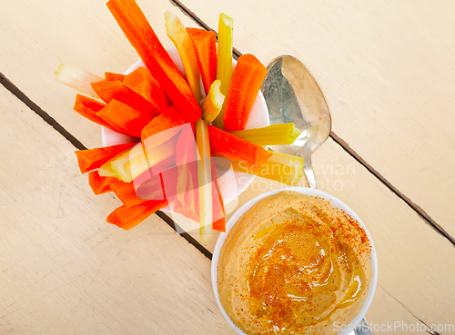 Image of fresh hummus dip with raw carrot and celery