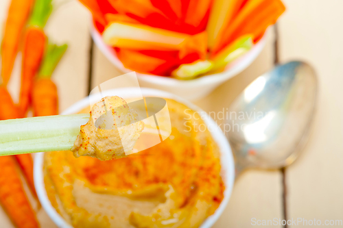 Image of fresh hummus dip with raw carrot and celery