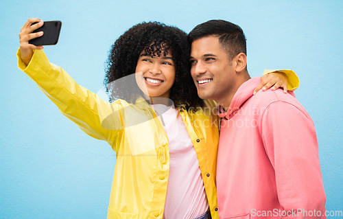 Image of Happy couple, bonding and phone selfie on isolated blue background for social media, profile picture and travel vlog. Smile, happy man and black woman on mobile photography technology in Brazil city