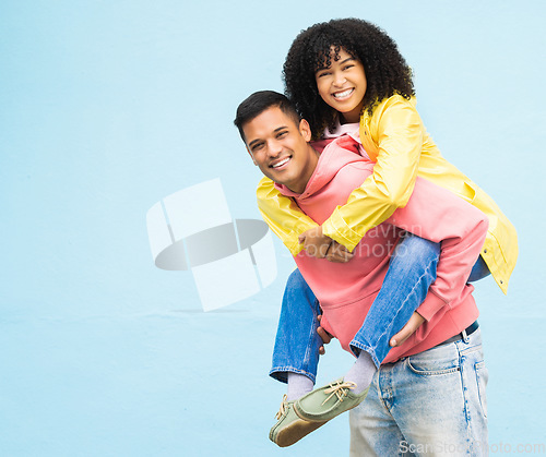 Image of Happy couple, bonding or piggyback portrait on isolated blue background in city travel, date or fun game. Smile, happy man or carrying black woman in silly, goofy or playful trust, support or love