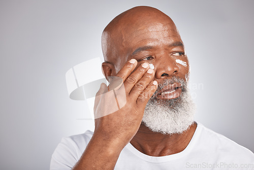 Image of Skincare, beauty or old man with facial cream marketing or advertising luxury beauty product for self care. Studio background, mockup space or senior black mans hand applying facial mask or cosmetics