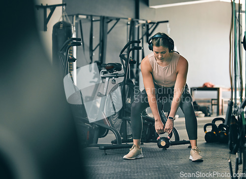 Image of Kettlebell weight, fitness gym woman with workout, training and exercise with headphones. Sport focus, wellness and healthy athlete busy with muscle and cardio development in a health studio