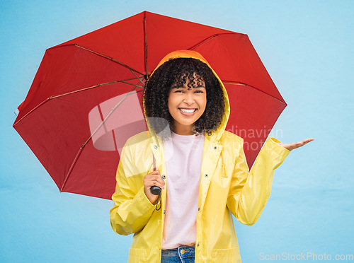 Image of Black woman, portrait and rain umbrella and hand checking for drops on isolated blue background in Brazil city. Happy person, student and raincoat for weather protection, rainfall water or insurance