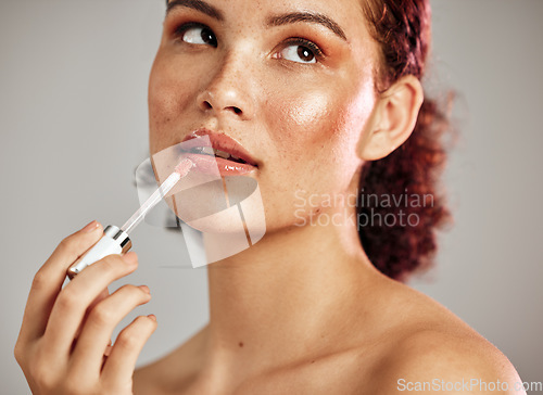 Image of Woman, lips and lipstick application for beauty, cosmetics dermatology and skincare wellness in grey background. Female model, thinking face and lip gloss brush or makeup product for self care