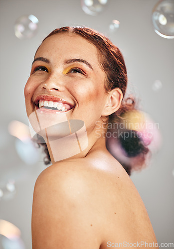 Image of Happy face, bubbles and woman in studio for skincare cosmetics, natural skin glow and dermatology. Facial makeup, health and wellness of aesthetic model person with luxury body product and hope