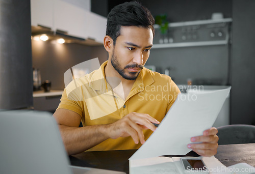 Image of Businessman, home office and documents by laptop in kitchen for focus, small business growth and opportunity. Digital entrepreneur, business owner and reading with contract, proposal and paperwork