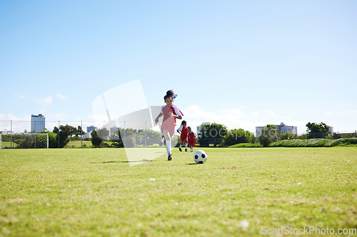 Image of Soccer, training or children and a girl team playing with a ball together on a field for practice. Fitness, football and grass with kids running or dribblinf on a pitch for competition or exercise