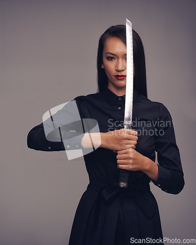 Image of Portrait, samurai and warrior with an asian woman in studio on a gray background for martial arts or combat. Training, fantasy and weapon with a model ninja ready to defend using self discipline