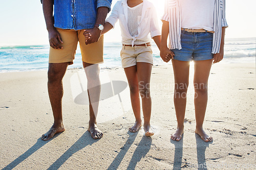 Image of Legs, beach and a black family holding hands together while standing on the sand by the sea on summer vacation. Feet, travel and a girl child on the coast with her mother and father by the ocean