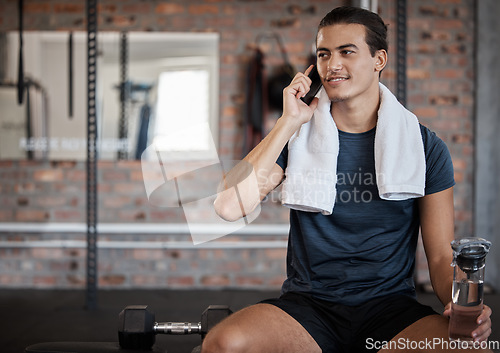 Image of Fitness, man and phone call with water bottle on bench with smile for conversation after workout at gym. Happy sporty male on smartphone in communication while taking a break from intense training