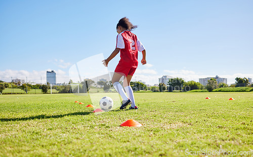 Image of Football girl child, field and training for fitness, sports and development of balance for control, speed and strong body. Female kid, fast soccer ball dribbling or workout feet on grass for learning