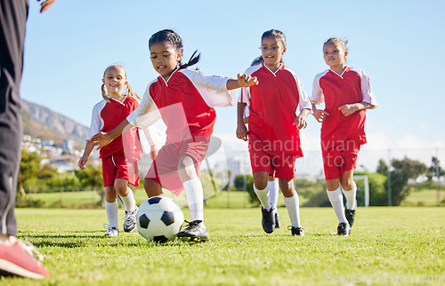 Image of Soccer, ball or sports and a girl team training or playing together on a field for practice. Fitness, football and grass with kids running or dribbling on a pitch for competition or exercise
