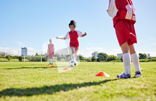Image of Soccer, training or running and a girl team playing with a ball together on a field for practice. Fitness, football and grass with sports kids dribbling on a pitch for competition or exercise
