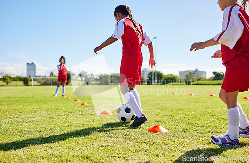 Image of Football, training or sports and a girl team playing with a ball together on a field for practice. Fitness, soccer and grass with kids running or dribbling on a pitch for competition or exercise