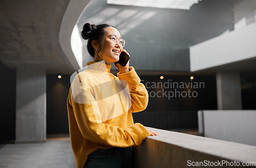 Image of Phone call, networking and mockup with an asian woman talking while standing in a hallway. Mobile, communication and conversation with an attractive young female speaking on her smartphone indoor