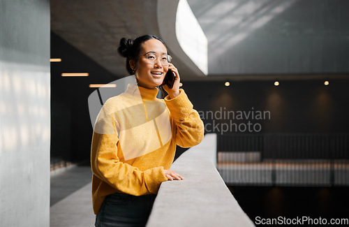 Image of Phone call, conversation and mockup with an asian woman talking while standing in a hallway. Mobile, networking and communication with an attractive young female speaking on her smartphone indoor