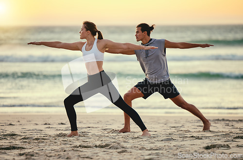 Image of Couple, warrior pose and beach yoga at sunset for health, fitness and wellness. Exercise, zen chakra and man and woman stretching, training and practicing pilates for balance outdoors at seashore.