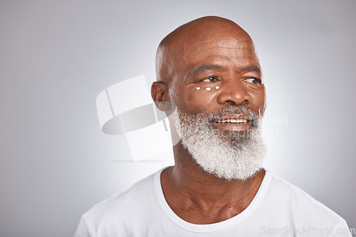 Image of Black man, beauty and facial cream for skincare of senior in studio for self care with dermatology and cosmetic product on skin. Face of happy male with lotion for glow, health and wellness on grey