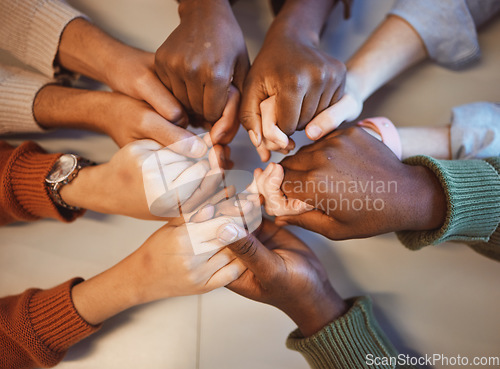 Image of Holding hands, top view and group prayer of people with hope, support or faith, religion or spiritual praise. Community, teamwork and Christian friends, men and women praying together to worship God.