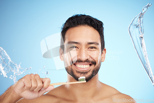 Image of Face, portrait or man brushing teeth in studio with toothbrush for white teeth or dental healthcare. Water splash, bamboo wood or happy person cleaning or washing mouth with a healthy natural smile