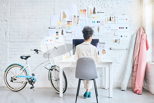 Image of Designer woman, workshop and desk by wall, moodboard and reading documents with sketch, planning or idea. Startup fashion expert, studio and sitting at table for small business growth, vision or goal
