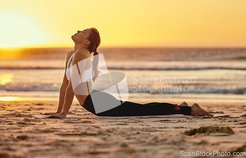 Image of Yoga, cobra stretch and woman at beach for fitness, health and wellness. Sunset, zen chakra and female yogi practicing pilates, meditation and training, stretching and exercise outdoors at seashore.