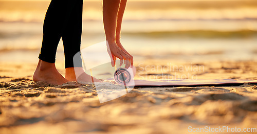 Image of Beach, hands and woman roll yoga mat getting ready for workout, exercise or stretching. Zen, meditation and feet of female yogi outdoors on seashore while start chakra training and pilates.