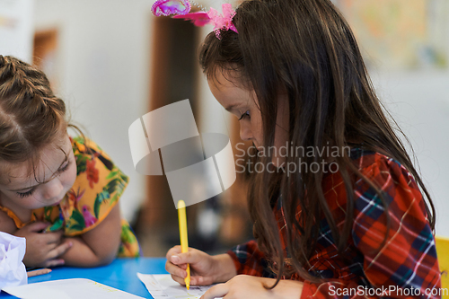 Image of Creative kids sitting in a preschool institution, draw and have fun while they get an education