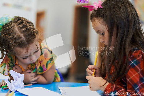 Image of Creative kids sitting in a preschool institution, draw and have fun while they get an education