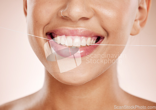 Image of Floss, woman and smile with dental care, clean mouth and after brushing teeth against studio background. Oral health, Latino female and girl with string, fresh breath and morning routine for hygiene