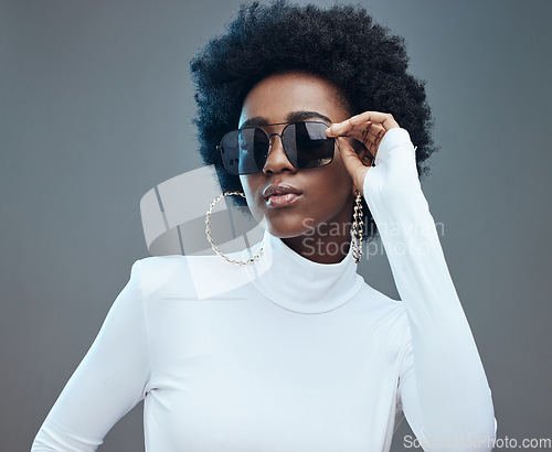 Image of Sunglasses, fashion and young black woman with gen z style and designer with trendy brand against studio background. Afro hair, edgy and girl, marketing with fashion model and stylish beauty