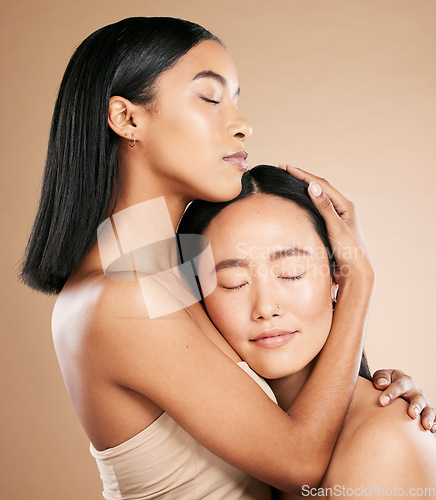 Image of Beauty, love and diversity with a model woman friends in studio on a beige background for natural skincare. Spa, health and wellness with an attractive young female holding the head of her friend