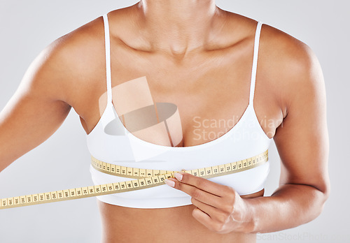 Image of Breast, measure tape and woman isolated on white background for cosmetics, plastic surgery and lose weight. Liposuction, health and wellness of person or model with boobs for beauty results zoom