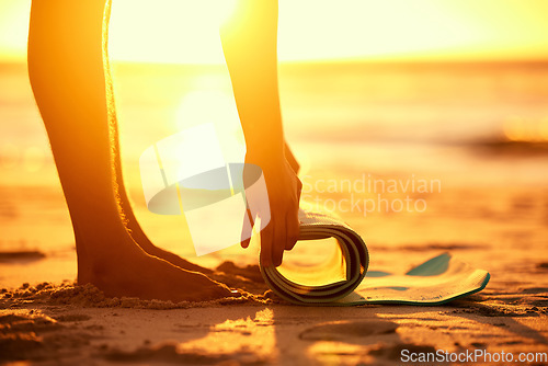 Image of Hands, beach and woman roll yoga mat getting ready for workout, exercise or stretching at sunset. Zen, meditation and feet of female yogi outdoors on seashore while preparing for training and pilates