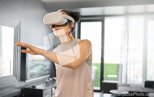 Image of Virtual reality, metaverse and technology with a woman in the living room of her home using a headset to access a 3d game. Futuristic, VR and gaming with a female gamer using ai to play games