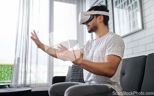 Image of Virtual reality, hands and man on sofa with futuristic headset for interactive, online and 3d games ux. Technology, digital tech and male relax with vr glasses for metaverse, cyberspace and gaming