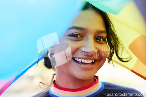 Image of Rainbow, flag and portrait with an indian woman in celebration of lgbt equality, freedom or gay pride. Community, support or human rights with a gender neutral or non binary female celebrating lgbtq