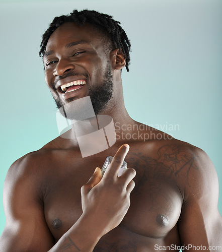 Image of Portrait, cologne and blue background with a model black man posing shirtless in studio for body spray. Perfume, product or skin with a handsome, muscular and young male standing topless on space