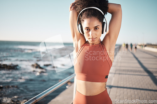 Image of Fitness music, ocean and woman portrait stretching for exercise warm up, running start or outdoor workout. Beach mockup, health and training African girl, athlete or runner listening to radio podcast