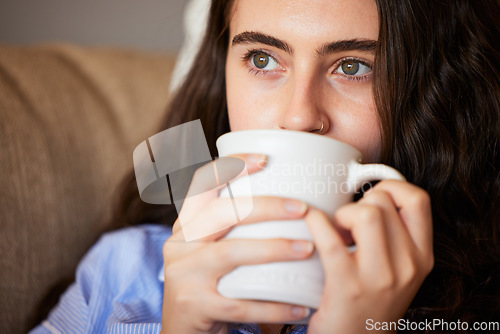 Image of Relax, calm and woman drinking coffee in the living room on a sofa in her modern house in Australia. Weekend, thinking and lady enjoying a cup of a warm caffeine or tea beverage in her lounge.