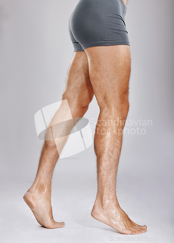 Image of Man, legs or muscles on studio background for fitness check, workout training goals or studio exercise wellness. Underwear model, bodybuilder and strong athlete feet on gray backdrop for healthcare