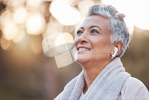 Image of Fitness, exercise and senior woman listening to music in nature with earphones for running , thinking and wellness. Face of an elderly female outdoor to run for a healthy lifestyle, body and energy