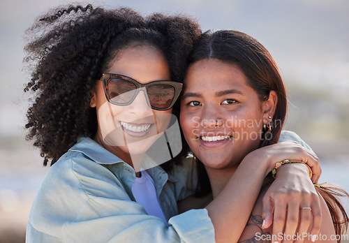 Image of Women, lgbtq and happy beach portrait for love, hug and care on summer holiday, vacation and rainbow pride. Gay, lesbian and young couple of friends relax at sea, ocean or outdoor happiness in nature