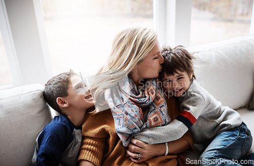 Image of Happy family, hug and kiss from mother to children while together on living room sofa at the house. Woman and kids in lounge for love, care and safety while bonding to relax and spend time at. home