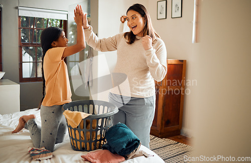 Image of Mother, child and high five for laundry basket, housework or helping with chores together at home. Happy mom and daughter celebrating for clean clothing, washing or victory for done or finished work