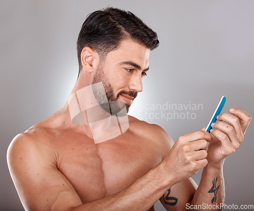 Image of Nail file, grooming and man in studio on gray background for body wellness, hygiene and skincare. Cosmetics, self care and strong male model with tools for hand care, cleaning and manicure treatment