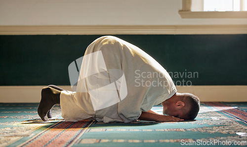 Image of Islam, religion and prayer of a muslim man at mosque in ramadan for spiritual faith, God and belief while doing religious worship. Islamic or Arab culture people sitting to pray at holy place